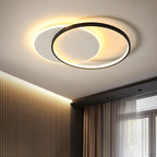 Orvena round ceiling light glowing warm above a bedroom with linen curtains