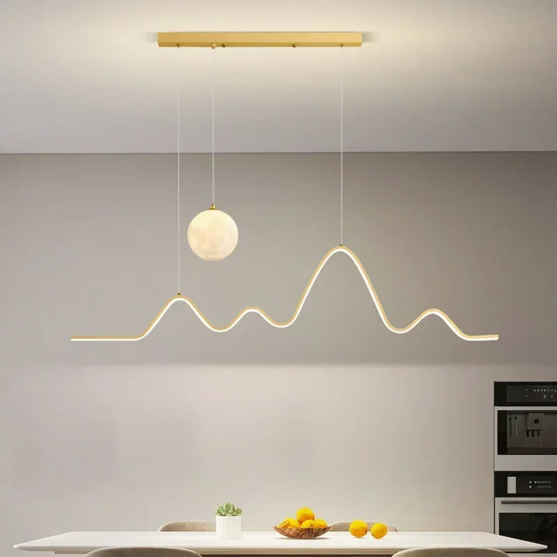 Modern Aluminum Wave Pendant Light with Moon Accent Qraeloria – Gold Lifestyle View