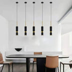 Polanthos angled cylinder spotlight pendants over a dining table, brass and black finish