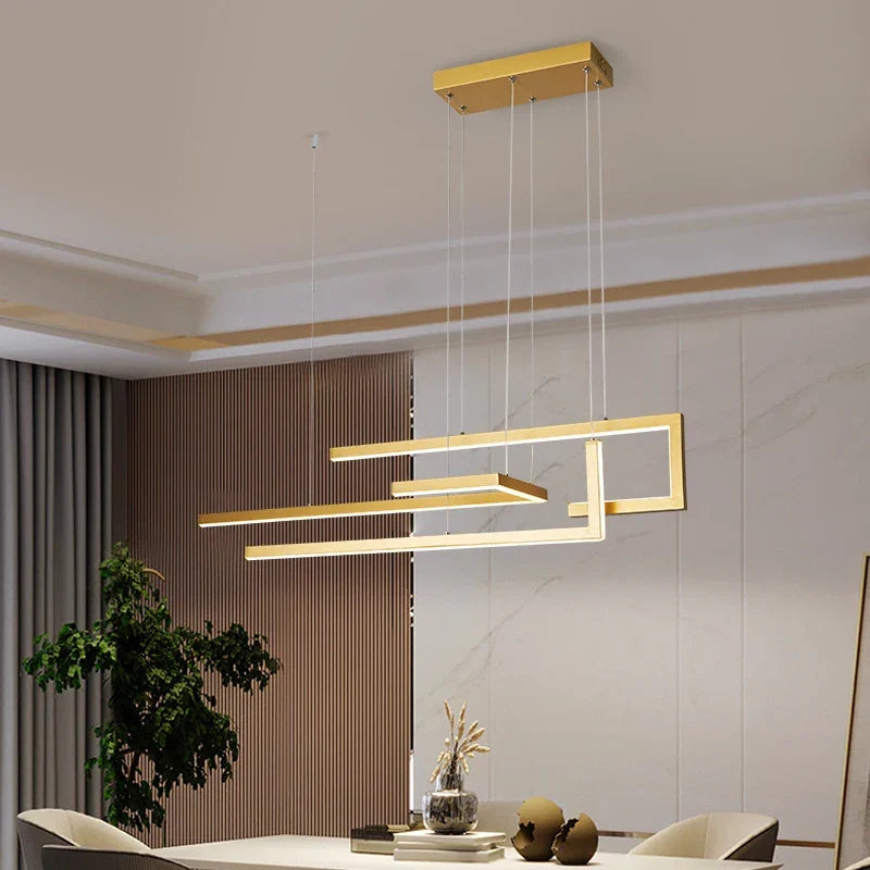Aurelux staggered linear bar pendant light in brushed gold over a dining table