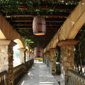 Suaelindra wood barrel pendant lights hanging above an outdoor pergola walkway
