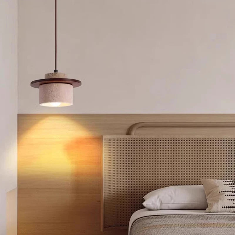 Iyaelvix travertine drum pendant light hanging above a bedside nightstand, natural stone texture