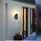 Galleron Disc wall sconce in black, outdoor patio at night