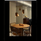 Yaelrix solid wood pendant lights over a round dining table, dark wood finish