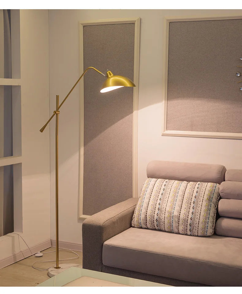 Aurevon gold floor lamp arched arm and dome shade detail beside sofa