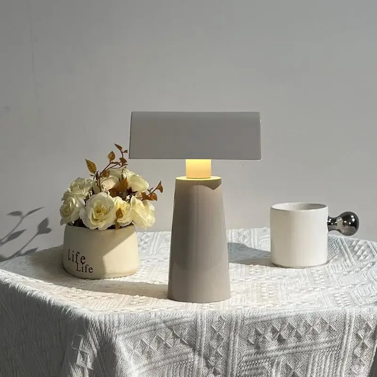 Cordless banker-style table lamp in milk gray with fresh flowers