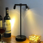 Tarvion rechargeable multi-spotlight LED table lamp — 2-head matte black version on a bar counter beside wine