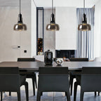 Torvalis smoked glass pendants above a dark dining table