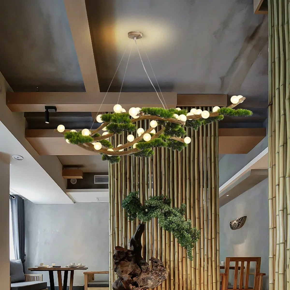 Veloris pine branch chandelier installed above a bamboo-accented dining area