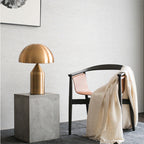 Bolentrix Brushed Gold mushroom table lamp on concrete pedestal in living room