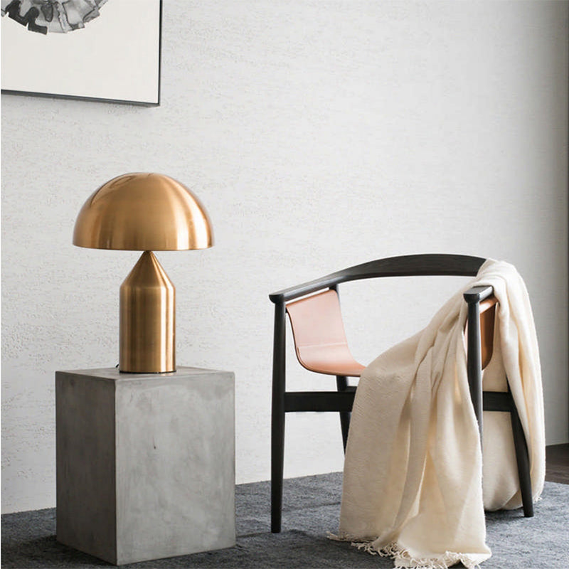 Bolentrix Brushed Gold mushroom table lamp on concrete pedestal in living room