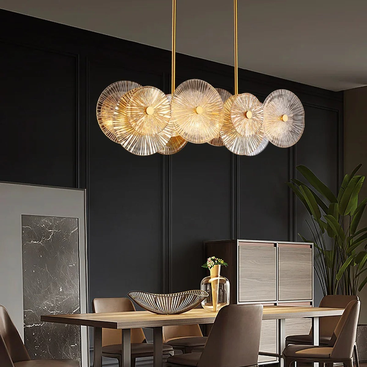 Iralux linear glass disc chandelier above a long dining table
