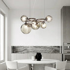Stellarix Bubble Cluster Chandelier suspended above a dining table, smoke grey glass spheres