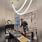 Halmira draped opal glass bead pendant lighting a dining room in warm light