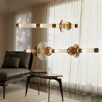Glass orb linear pendant Prismova — horizontal brass bar with white glass orbs and amber tinted disc spacers, minimalist living room