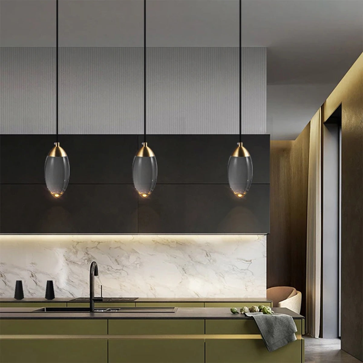 Three Ovaline pendant lights in a row over a kitchen counter
