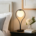 Haloria black arc globe table lamp on dark wood bedside table
