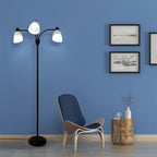 Merelix floor lamp lit with cool white E27 bulbs beside a reading chair