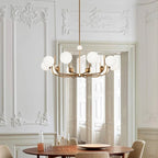 Opal globe sputnik chandelier in brushed gold above a round dining table in a classic Haussmann-style dining room — Noctivox
