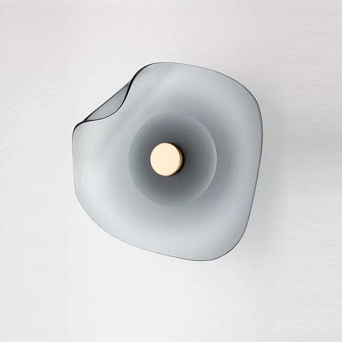 Devoria wall sconce, unlit, in smoky grey, front view showing the organic curved glass form and gold disc centre