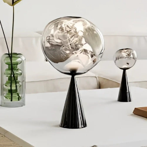 Dixora chrome mirror ball table lamp on white desk reflecting room