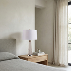 Orindel table lamp with white fabric shade on a wood nightstand in a modern bedroom