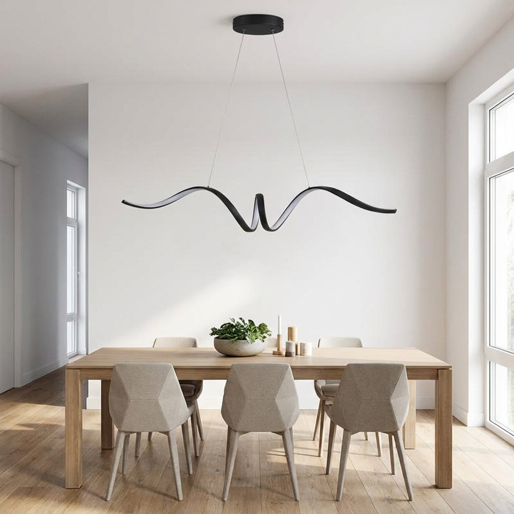 Sculptural aluminium wave pendant light in black finish over a wooden dining table