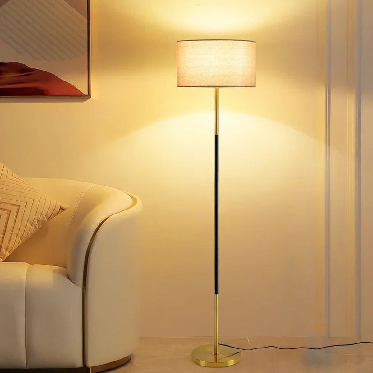 Silent floor lamp — gold brass stem with natural linen drum shade in living room