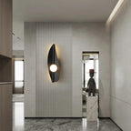 Wabi-Sabi Leaf-Form Wall Sconce Velanthos — black finish in entryway setting
