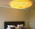 Fornox pleated fabric saucer light, flush mount, warm ambient glow above bed