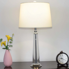 Orindel crystal column table lamp on a dark console with a pink vase and clock