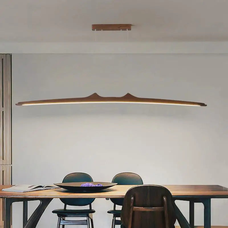 Firion walnut pendant over a dining table with chairs
