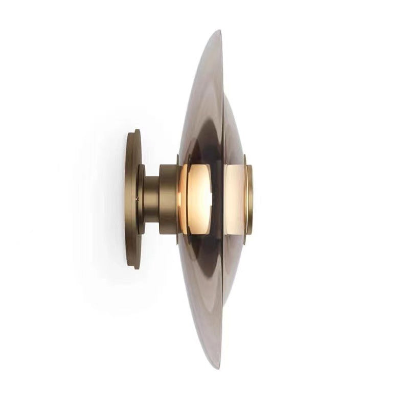 Cognac smoked glass disc wall sconce, studio shot, brass hardware — Cevanix