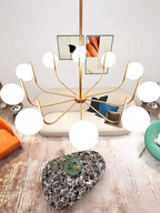 Overhead view of the 10-light Noctivox chandelier in brushed gold showing the full arm and globe arrangement