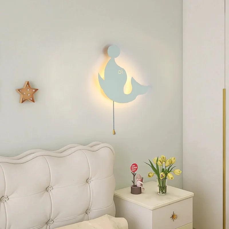 Nubira Dolphin metal wall light illuminated beside a bed