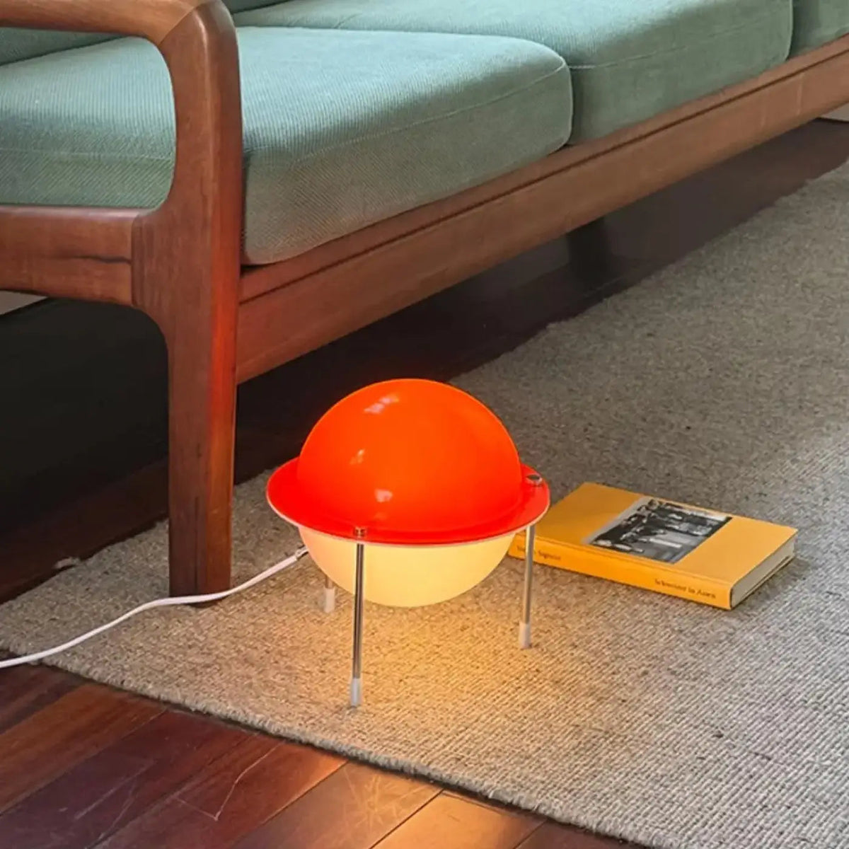Saturnira retro space-age Saturn floor lamp – orange globe beside mid-century sofa