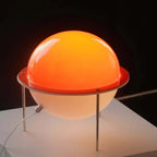 Saturnira Saturn lamp glowing with warm diffused light in living room corner