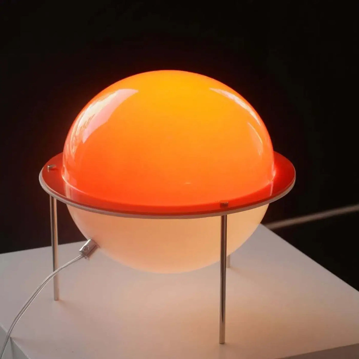 Saturnira Saturn lamp glowing with warm diffused light in living room corner
