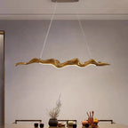 Sculptural wave-form pendant light Velorix wood-tone finish over tea table