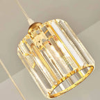 Nzaelion crystal cylinder pendant – close-up of gold faceted crystal prisms and brass frame, lit