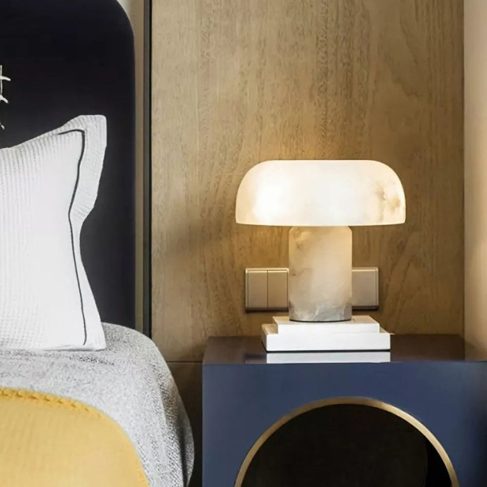 Virella alabaster mushroom table lamp glowing warmly on navy blue nightstand