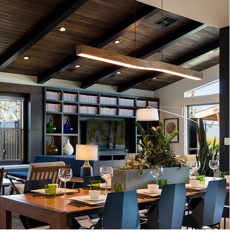 Yalvix wave-form linear pendant, 120 cm, warm glow in an open-plan dining and living space